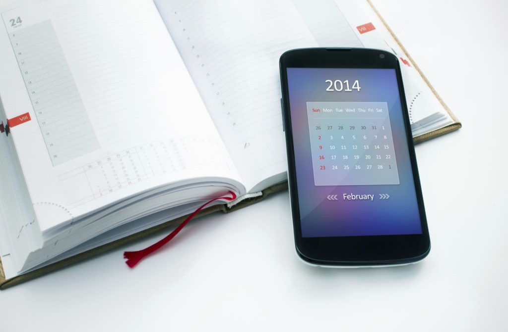 Modern mobile phone with calendar for February 2014.